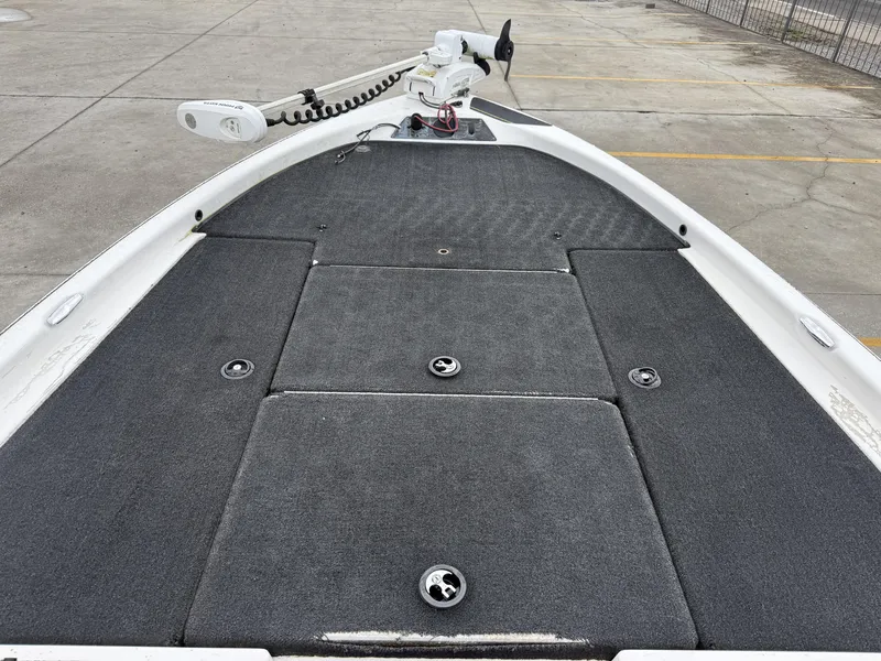 Slide: The Image of 2005 Skeeter SX 200 boat deck with carpeted surface and trolling motor. - 13