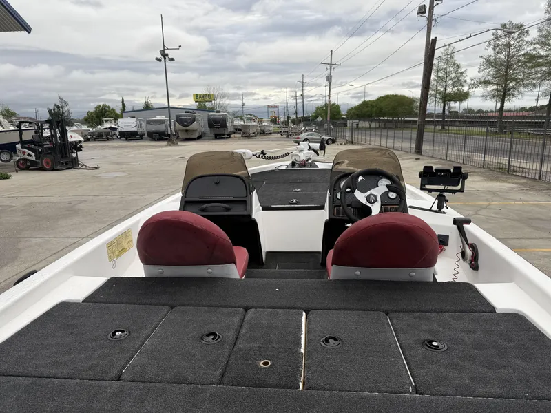Slide: The Image of 2005 Skeeter SX 200 boat interior with dual seats and steering wheel, parked outdoors. - 14
