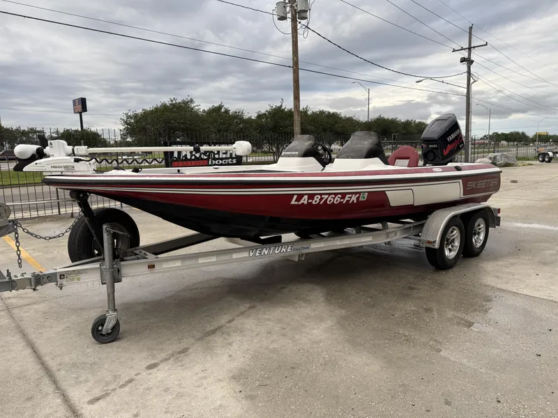 Slide: The Image of 2005 Skeeter SX 200 boat on trailer, red and white, parked outdoors. - 3