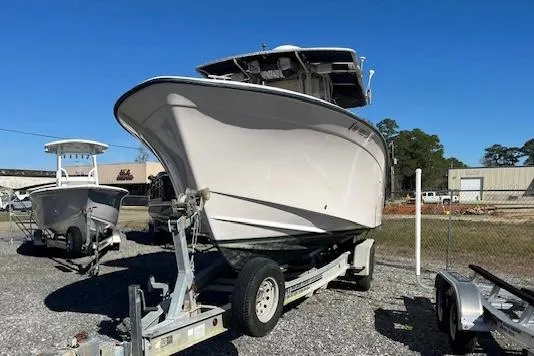 Slide: The Image of 2003 Grady-White 306 CC boat on trailer, parked outdoors under clear blue sky. - 7