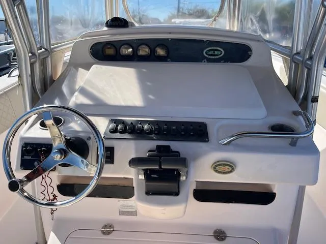 Slide: The Image of 2003 Grady-White 306 CC boat helm with steering wheel and control panel. - 8