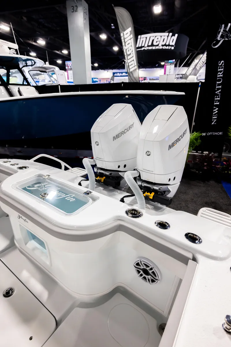 Slide: The Image of 2025 Yellowfin 32 Offshore boat with dual Mercury engines at a boat show. - 12
