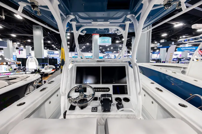 Slide: The Image of 2025 Yellowfin 32 Offshore boat interior with modern dashboard and controls at a boat show. - 14