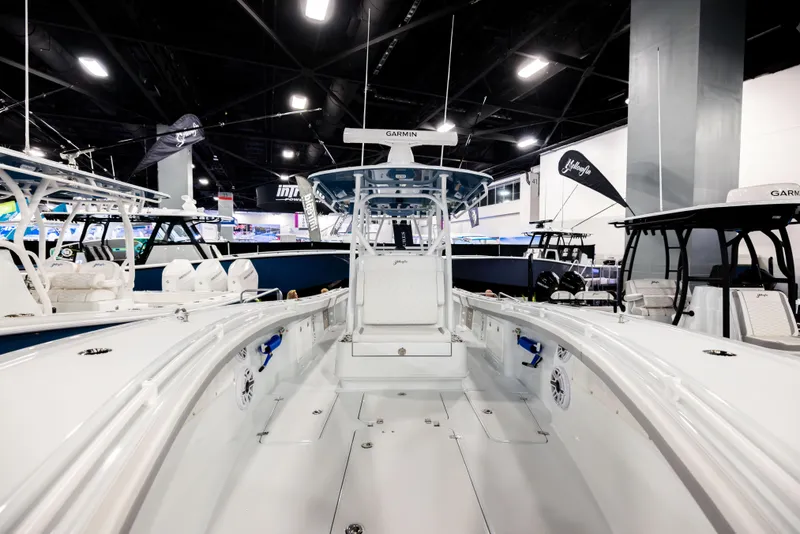 Slide: The Image of 2025 Yellowfin 32 Offshore boat displayed at an indoor exhibition, showcasing sleek design and spacious deck. - 15