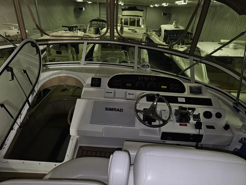 Slide: The Image of 2001 Cruisers Yachts 5000 Sedan Sport helm with Simrad navigation system in a showroom. - 11
