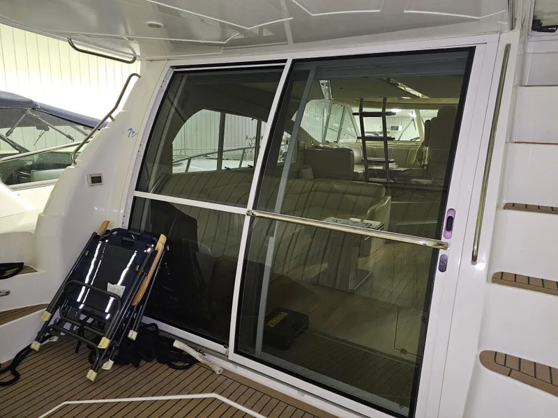 Slide: The Image of 2001 Cruisers Yachts 5000 Sedan Sport interior with sliding glass door and wooden deck. - 8