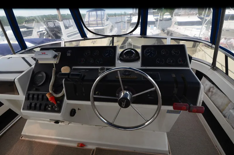 Slide: The Image of 1993 Carver 350 Aft helm with steering wheel and control panel, docked at marina. - 21