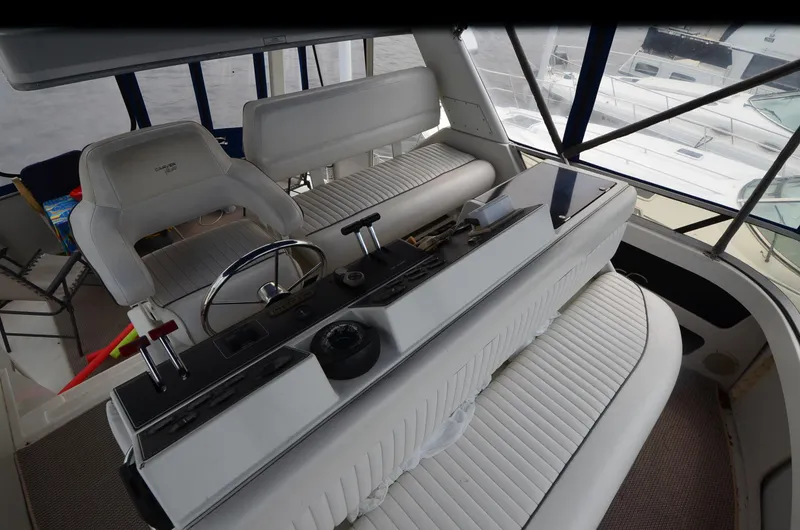 Slide: The Image of 1993 Carver 350 Aft yacht interior with helm, white seating, and control panel. - 23
