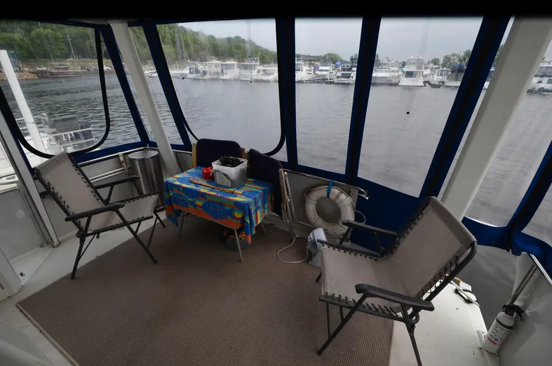 Slide: The Image of Interior of 1993 Carver 350 Aft yacht with chairs and table, overlooking marina. - 26