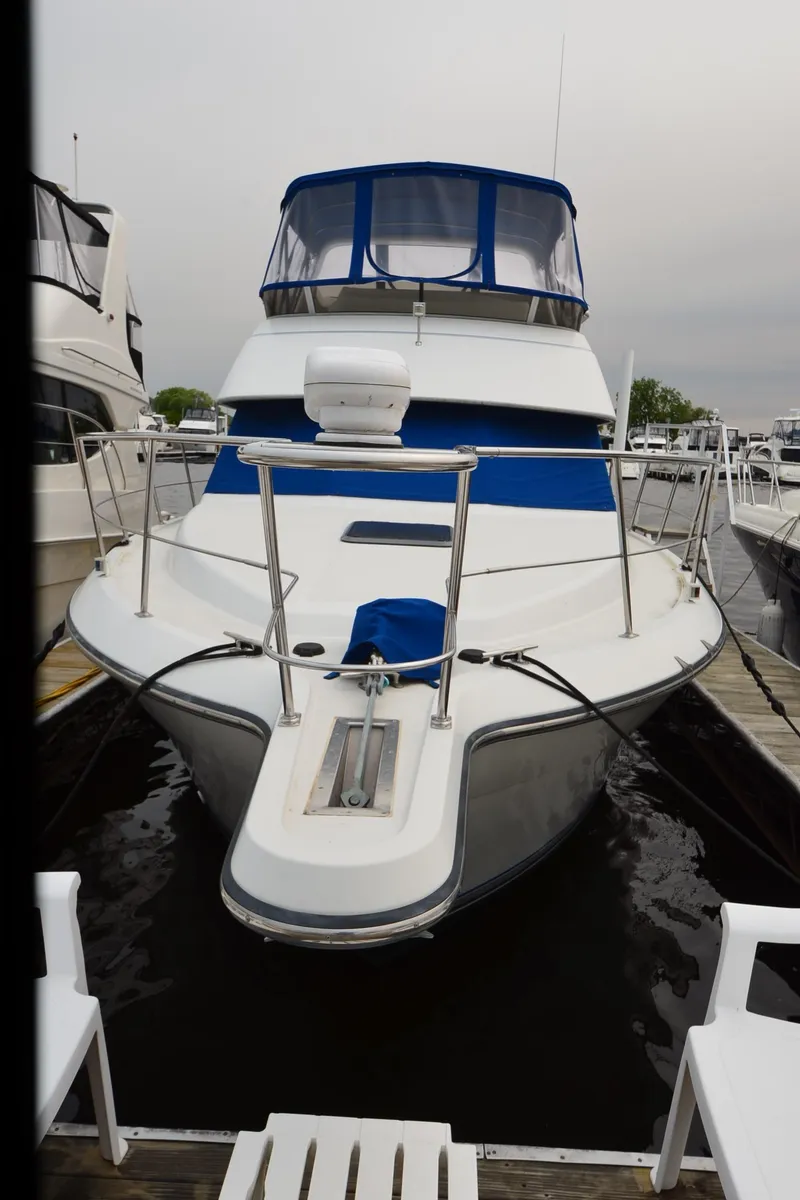 Slide: The Image of 1993 Carver 350 Aft yacht docked, featuring blue accents and spacious deck. - 27
