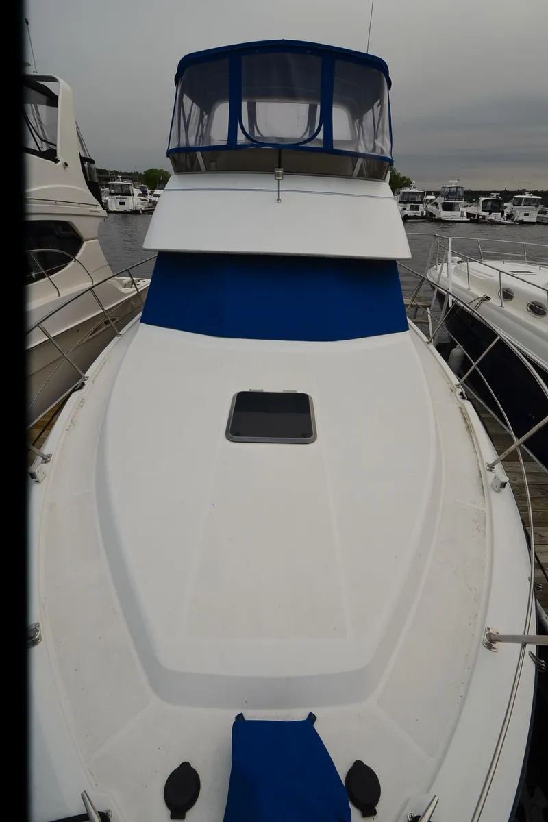 Slide: The Image of 1993 Carver 350 Aft yacht with blue accents docked at marina. - 28