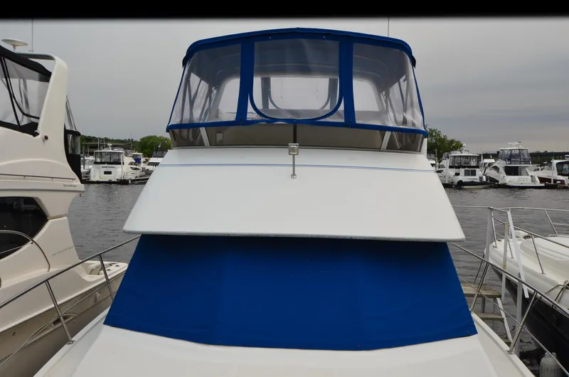 Slide: The Image of 1993 Carver 350 Aft yacht with blue canopy docked at marina. - 30