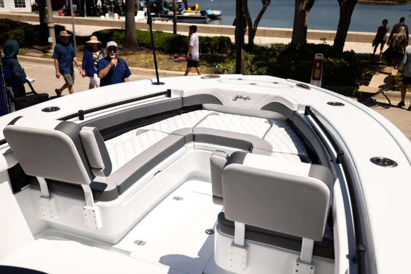 Slide: The Image of 2025 Yellowfin 26 Hybrid boat with spacious seating, docked near a waterfront promenade. - 6