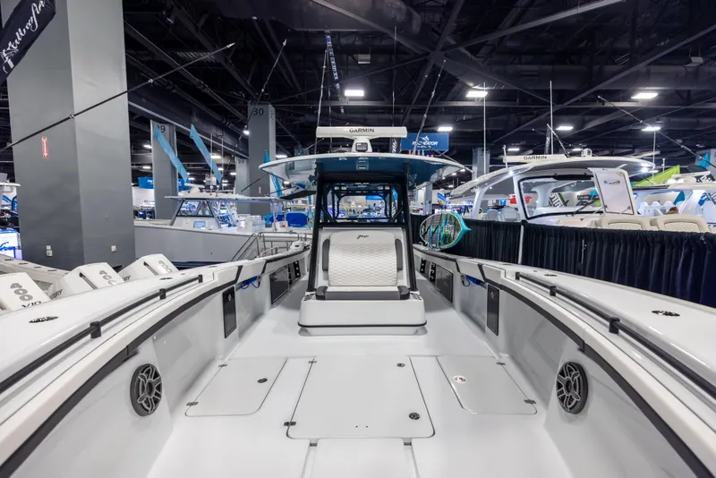 Slide: The Image of 2025 Yellowfin 39 Offshore boat interior at a boat show, showcasing spacious deck and seating. - 14