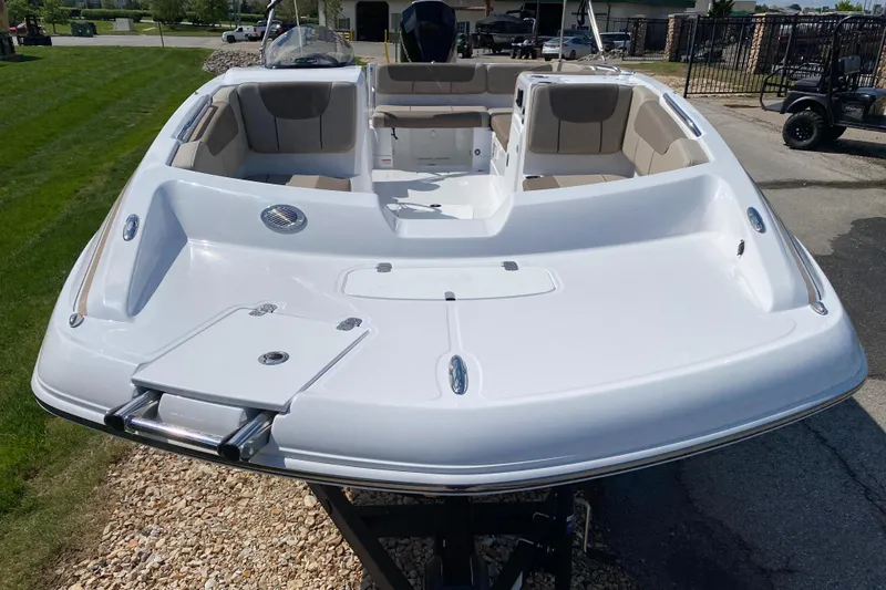 Slide: The Image of 2025 Tahoe 2150 boat with spacious seating and sleek design, parked outdoors. - 2