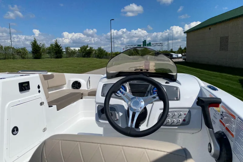 Slide: The Image of 2025 Tahoe 2150 boat interior with steering wheel, dashboard, and seating under a clear blue sky. - 4