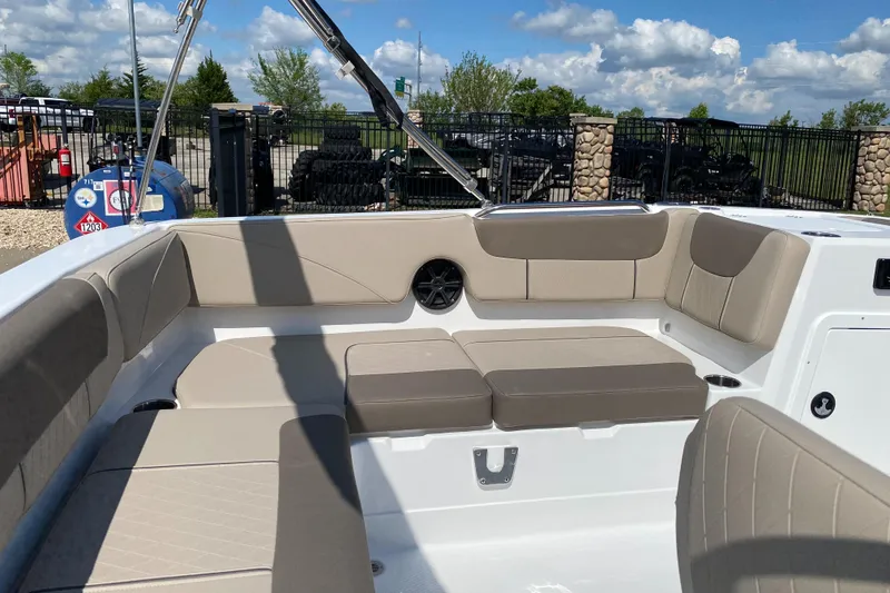 Slide: The Image of 2025 Tahoe 2150 boat interior with beige seating, outdoor setting, and blue sky. - 5