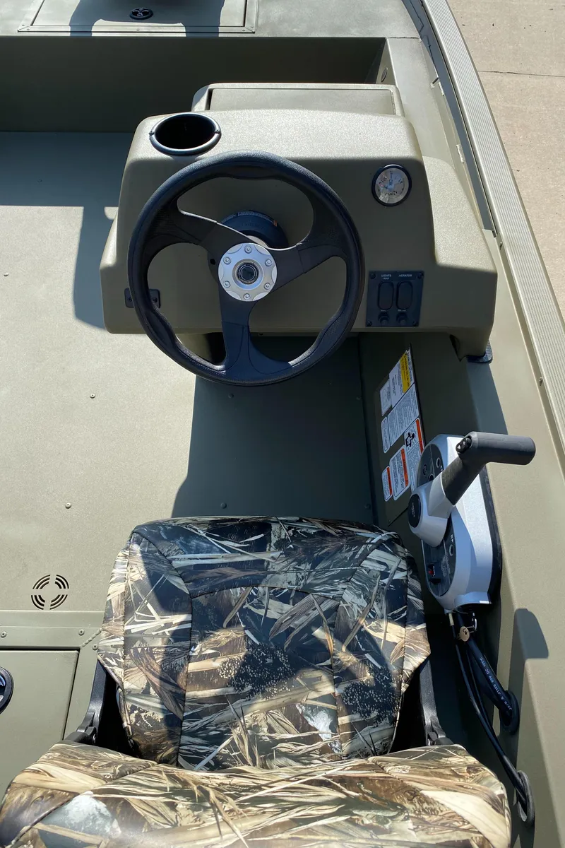 Slide: The Image of 2025 Tracker Grizzly 1754 SC boat interior with steering wheel and camo seat. - 6