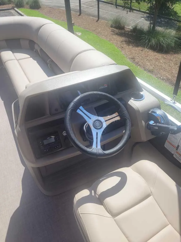 Slide: The Image of 2025 Sun Tracker SportFish 22 DLX pontoon boat with spacious seating and canopy. - 4