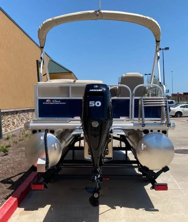 Slide: The Image of 2025 Sun Tracker Bass Buggy 16 XL Select pontoon boat with Mercury 50 engine, parked outdoors. - 5