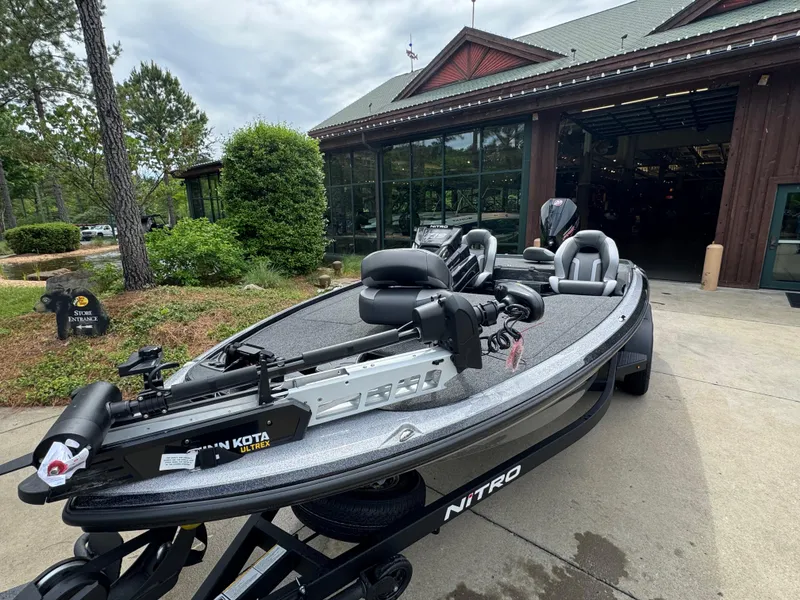 Slide: The Image of 2025 Nitro Z19 Pro fishing boat parked outside a rustic building. - 2