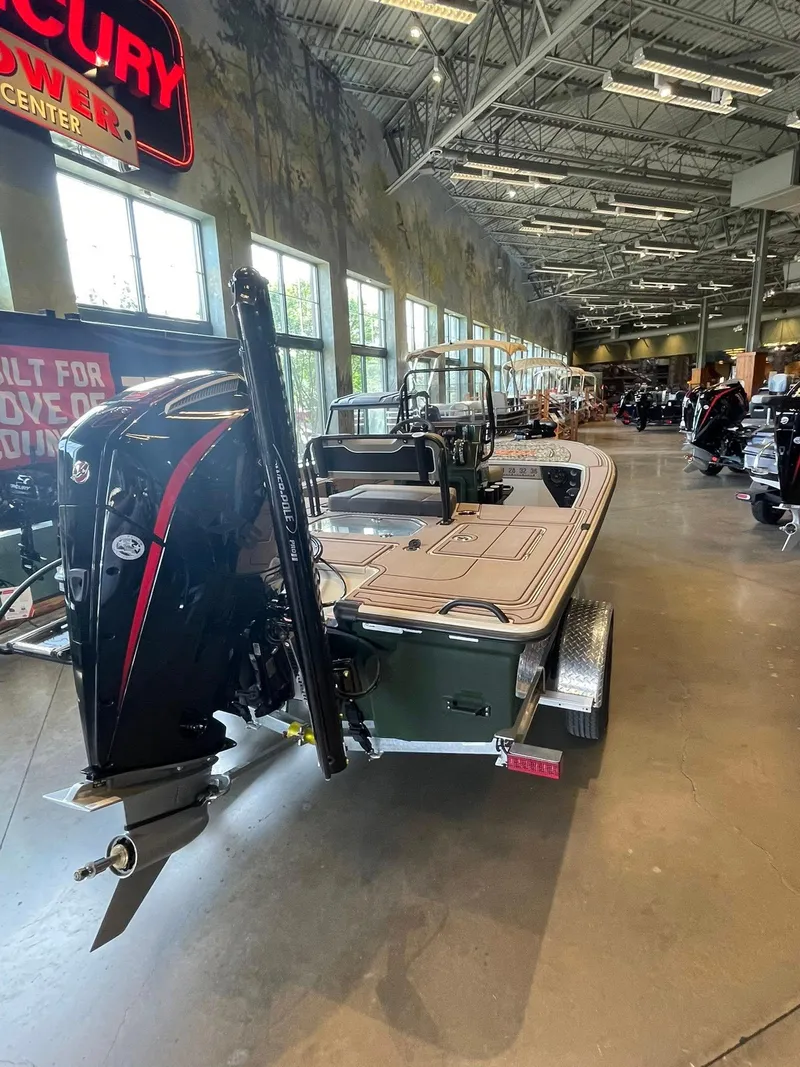 Slide: The Image of 2025 Mako 18 Pro Skiff Backwater Edition displayed in a showroom with outboard motor. - 3