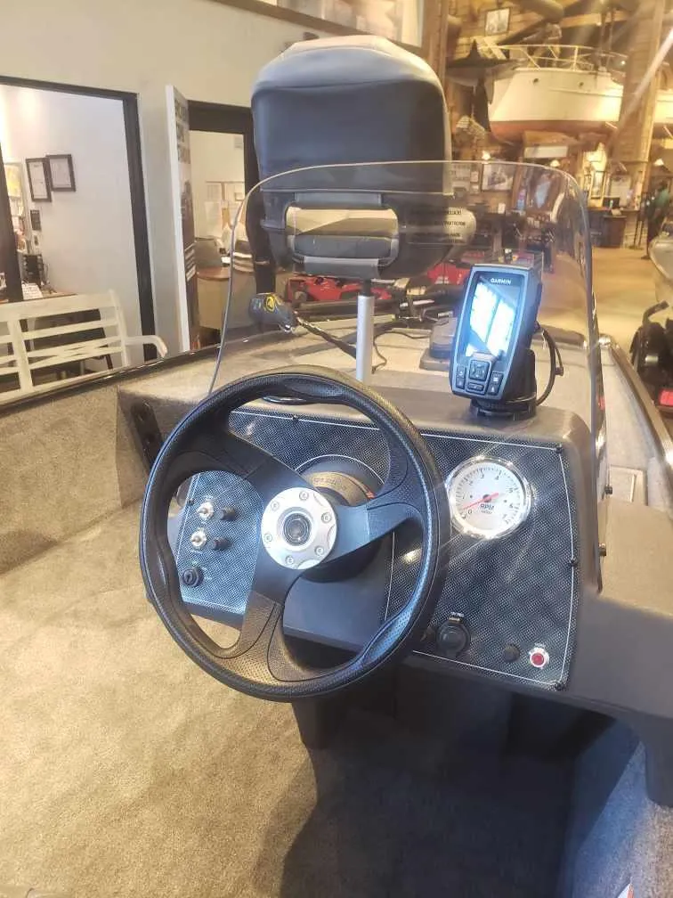 Slide: The Image of 2025 Tracker Bass Tracker Classic XL boat dashboard with steering wheel and navigation system. - 17
