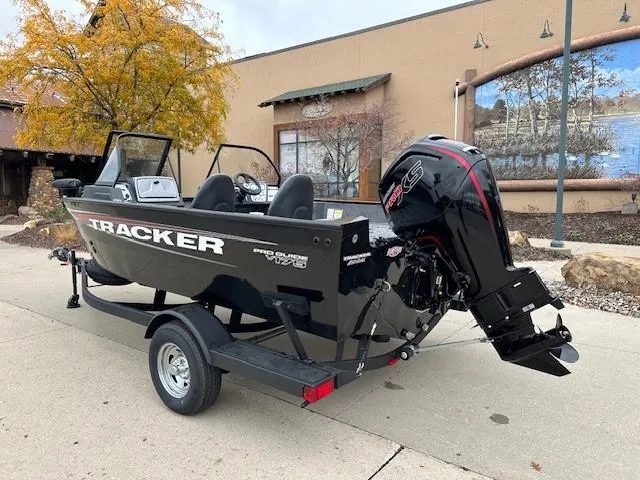 Slide: The Image of 2025 Tracker Pro Guide V-175 WT boat on trailer, parked outdoors. - 2