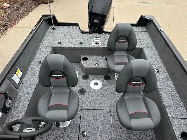 Slide: The Image of 2025 Tracker Pro Guide V-175 WT boat interior with four gray seats and steering wheel. - 8