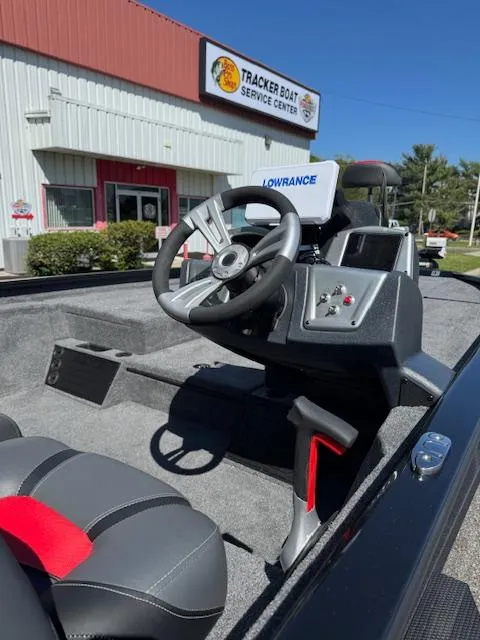 Slide: The Image of 2025 Tracker Savage 215 boat interior at service center, featuring steering wheel and navigation system. - 10