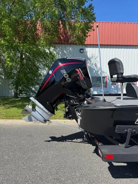 Slide: The Image of 2025 Tracker Savage 215 boat with powerful outboard motor, parked outdoors. - 5