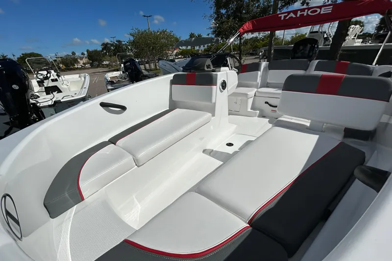 Slide: The Image of 2025 Tahoe T16 boat interior with white and gray seating, red accents, and canopy. - 2