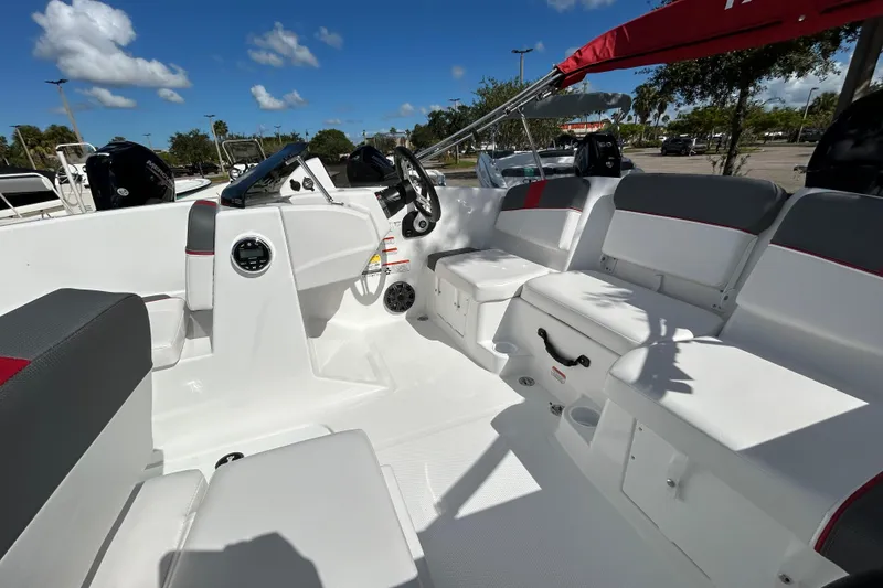 Slide: The Image of 2025 Tahoe T16 boat interior with seating, steering wheel, and dashboard under a clear blue sky. - 3