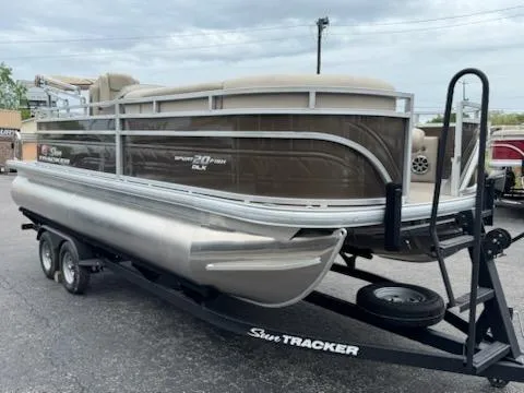 Slide: The Image of 2025 Sun Tracker SportFish 20 DLX pontoon boat on trailer, parked outdoors. - 2