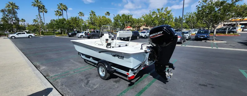 Slide: The Image of 2025 Mako Pro Skiff 17 CC boat on trailer in parking lot, sunny day. - 0