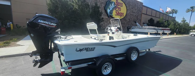 Slide: The Image of 2025 Mako Pro Skiff 17 CC boat on trailer outside Bass Pro Shops. - 1