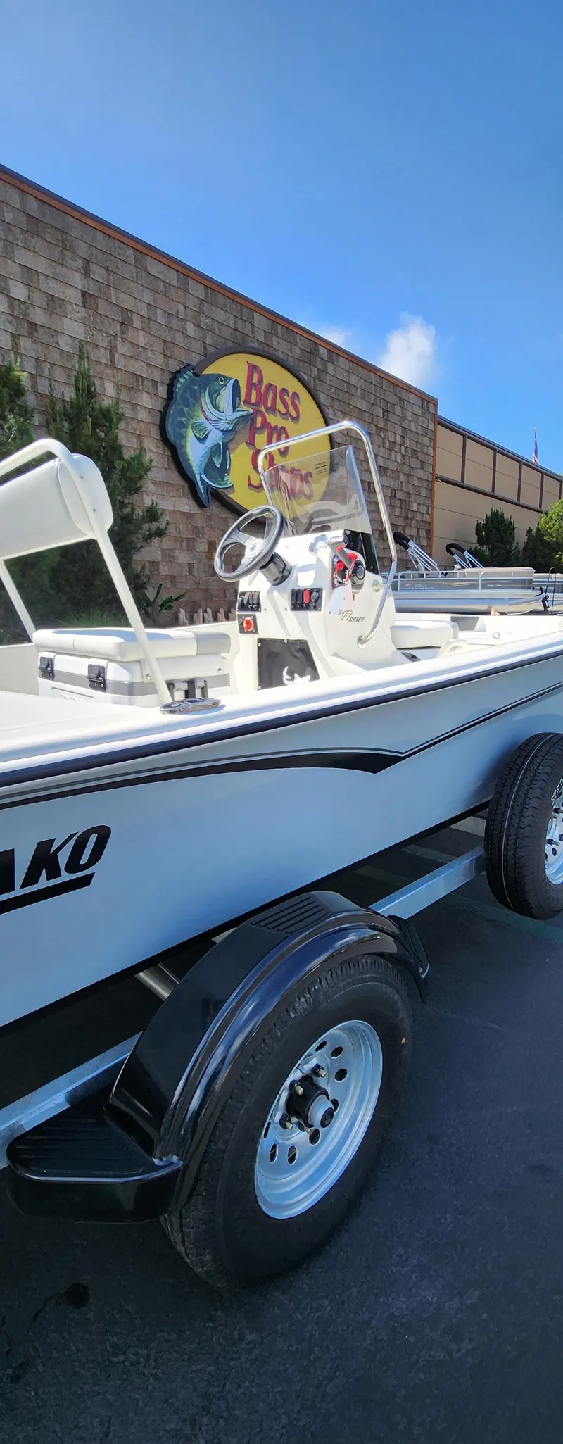 Slide: The Image of 2025 Mako Pro Skiff 17 CC boat on trailer outside Bass Pro Shops. - 5