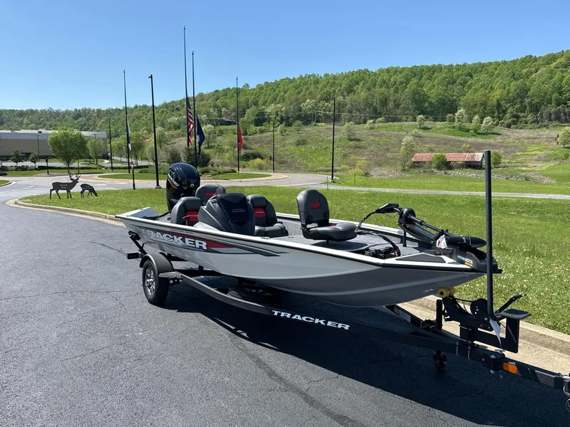 Slide: The Image of 2025 Tracker Pro Team 175 boat on trailer, parked outdoors on sunny day. - 2