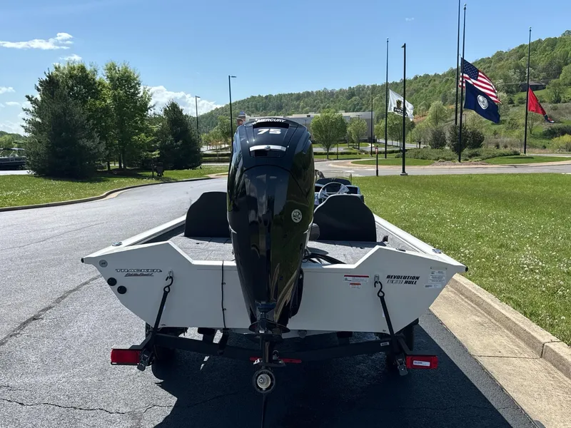 Slide: The Image of 2025 Tracker Pro Team 175 boat on trailer, parked outdoors with flags in the background. - 5