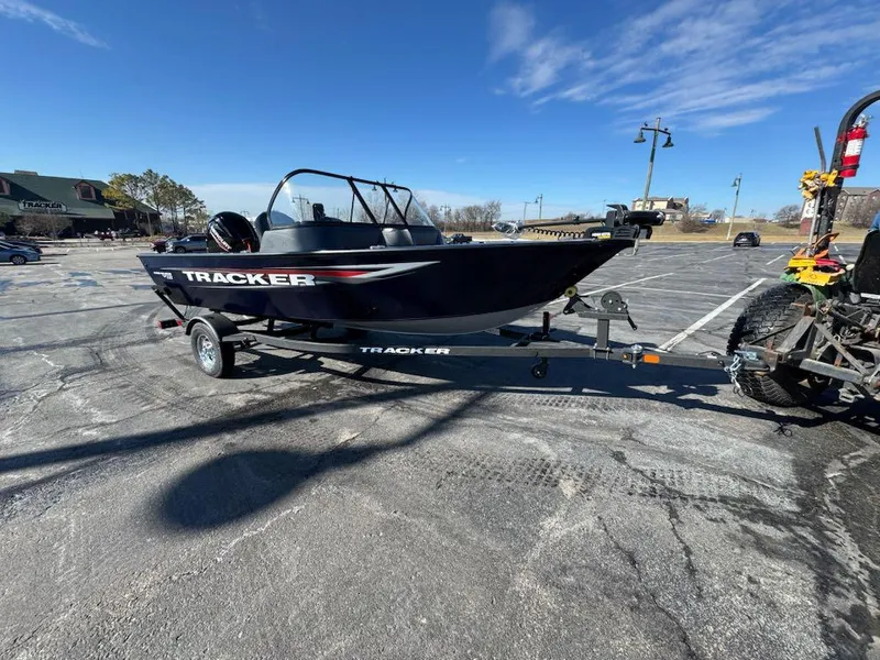 Slide: The Image of 2025 Tracker Pro Guide V-16 SC boat on trailer in parking lot. - 2