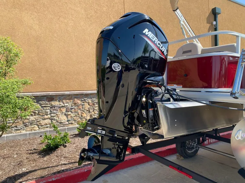 Slide: The Image of 2025 Sun Tracker Bass Buggy 18 DLX with Mercury outboard motor, parked outdoors. - 5