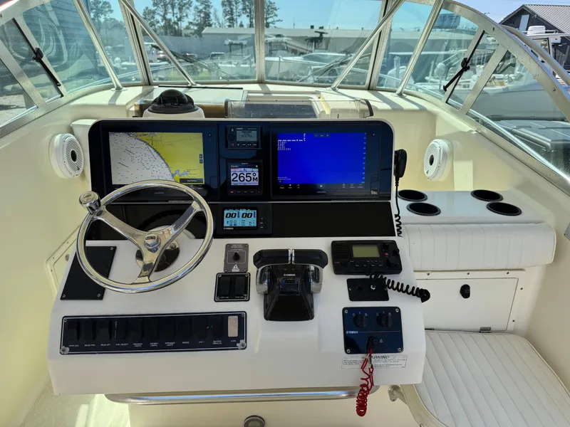 Slide: The Image of 2001 Pursuit 3070 boat helm with navigation screens and steering wheel. - 3