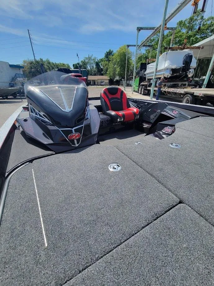 Slide: The Image of 2021 Ranger Z520L boat with sleek design and red-accented seating, parked outdoors. - 17