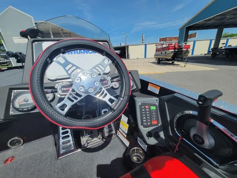 Slide: The Image of 2021 Ranger Z520L boat cockpit with steering wheel and control panel, outdoor setting. - 18