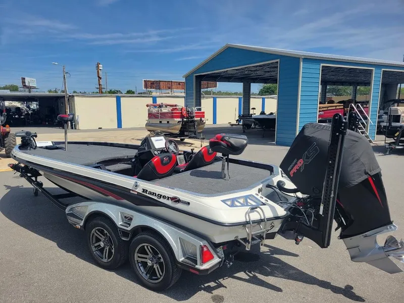 Slide: The Image of 2021 Ranger Z520L boat with dual seats and motor, parked outdoors. - 2