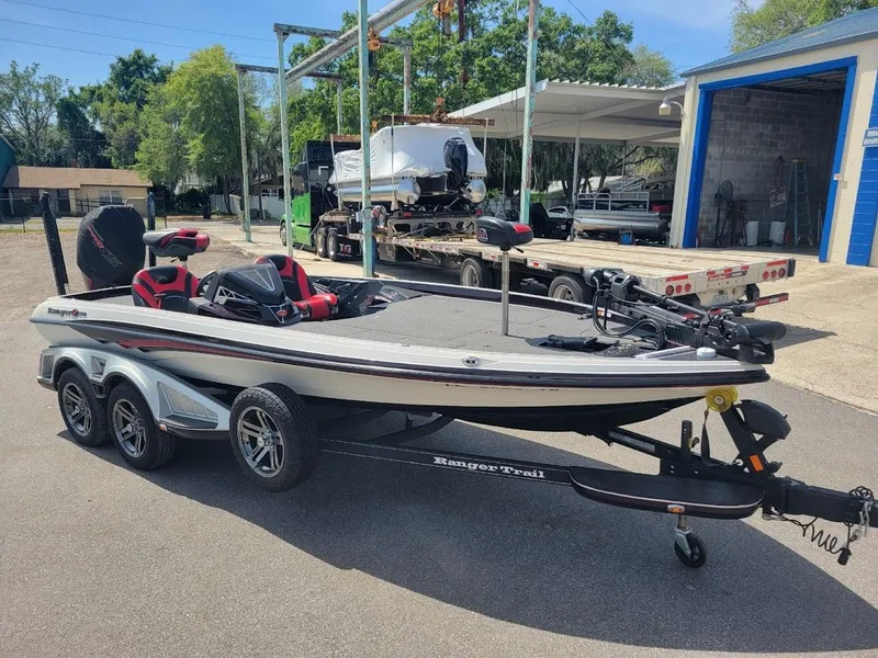 Slide: The Image of 2021 Ranger Z520L boat on trailer, parked outdoors near a workshop. - 8