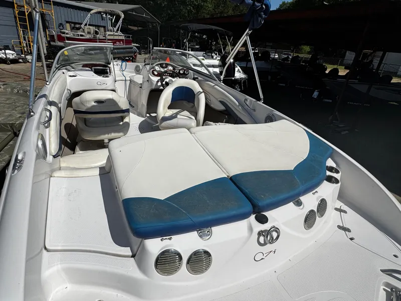 Slide: The Image of 2011 Tahoe Q7i boat interior with white and blue seating, docked in a marina. - 19