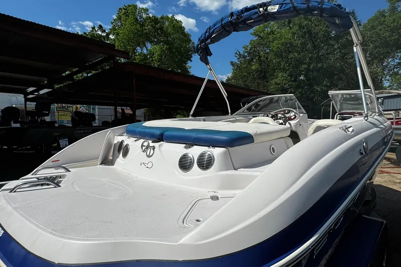 Slide: The Image of 2011 Tahoe Q7i boat with blue accents, docked under a sunny sky. - 21