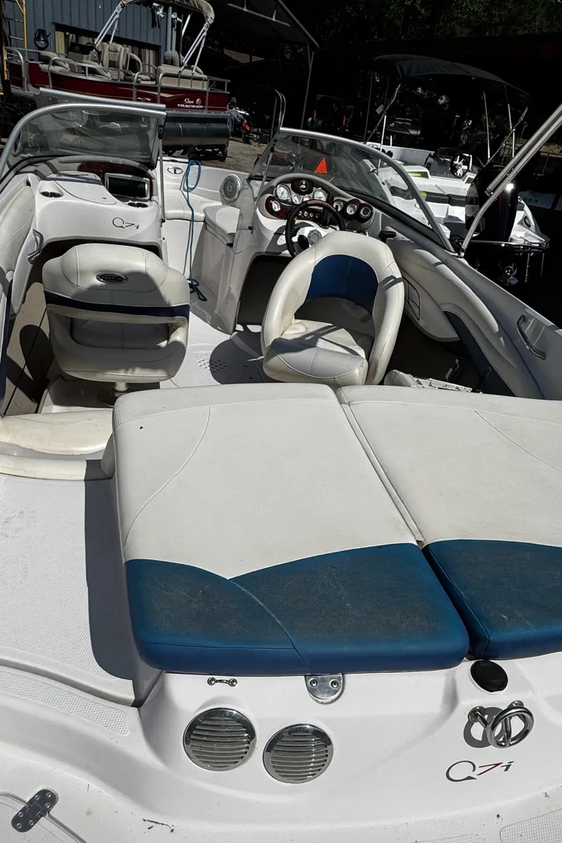 Slide: The Image of 2011 Tahoe Q7i boat interior with white and blue seating, docked at a marina. - 22
