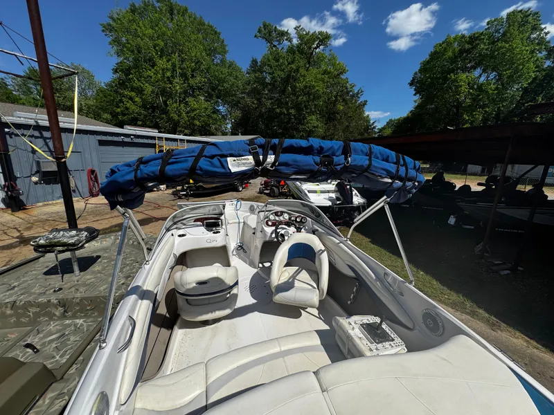 Slide: The Image of 2011 Tahoe Q7i boat with blue cover, parked outdoors under clear sky. - 4
